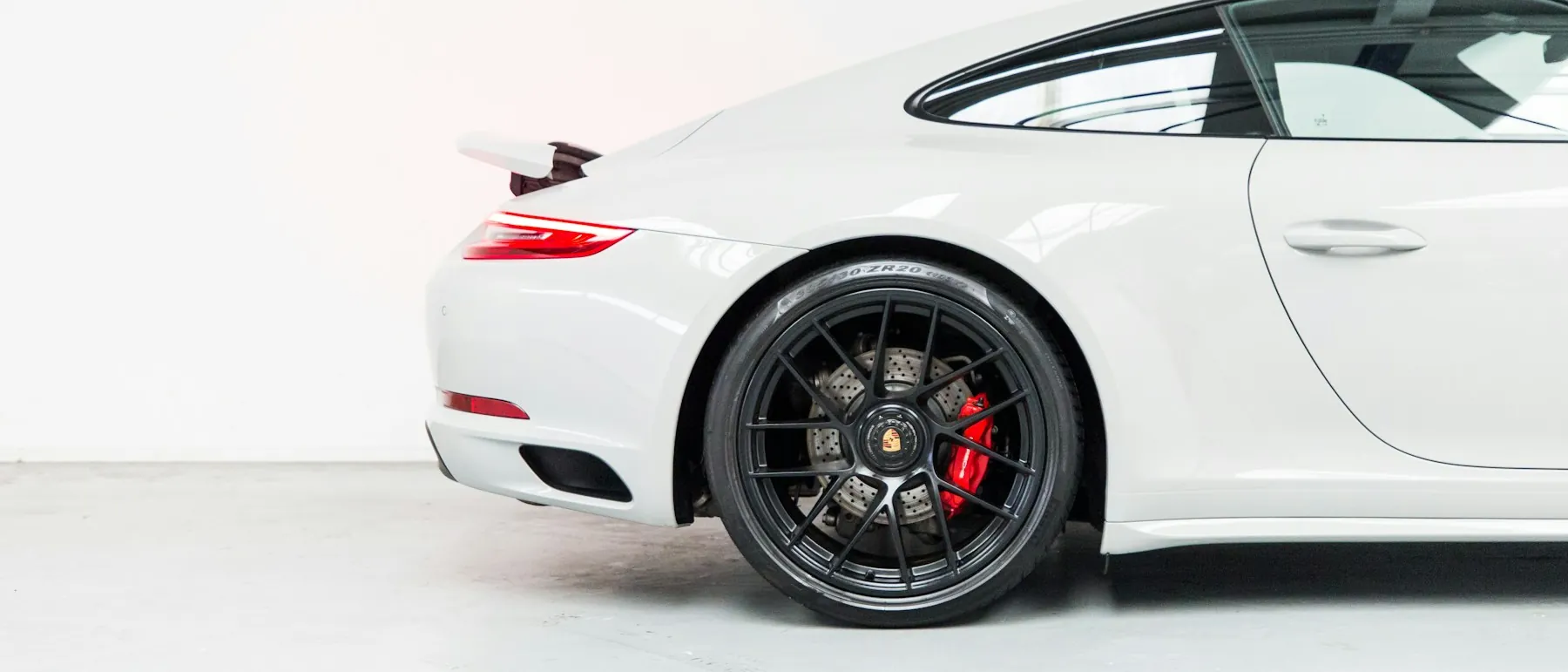Beyaz spor otomobilin arka çeyreği ve siyah alaşım jantı
